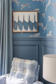 a bedroom with blue walls and wallpaper that has zebras painted on the wall