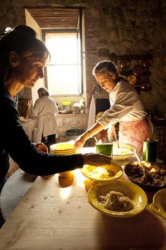 two women preparing food in a rustic kitchen