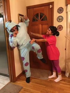 a man and woman dressed in costumes standing next to each other near a refrigerator door