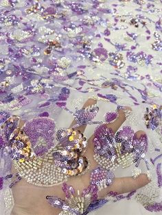 a woman's feet covered in purple sequins and beads on a white surface