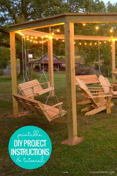 a wooden swing set with lights hanging from the ceiling and some chairs on the ground