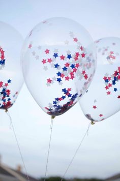 some balloons with stars on them are in the air