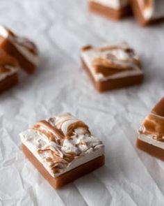 several pieces of caramel and marshmallow dessert on white paper with brown icing