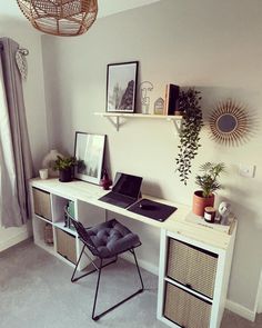 a laptop computer sitting on top of a white desk next to a chair and potted plant