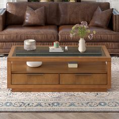 a living room with a couch, coffee table and vases on the end tables