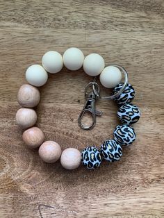 a bracelet made out of wooden beads and leopard print bead on top of a wood table