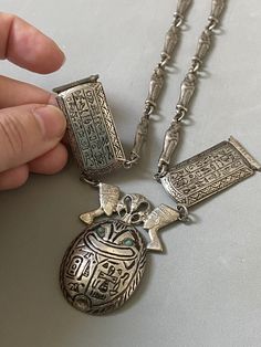 Very rare, the 1940s giant Egyptian Scarab necklace from silver 800,  hallmarked with Egyptian hallmarks for 1946,  and silver 800. Hollow silver (empty) necklace with oversized figures of the  Scarab with turquoise stone eyes,  with lotus flower and  Nefertitis on the top, with  Hieroglyphs tables and actually -  everywhere, and with mummies as a chain. The  necklace is short, close to the neckline, 39.5cm long. If you need longer, you could buy an extension chain from internet.   Condition is Scarab Necklace, Egyptian Scarab, Witchy Jewelry, Snake Ring, Turquoise Stone, Lotus Flower, Vintage Necklace, Pendant Necklaces, Vintage Shops