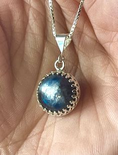 "6-Carats, natural round, 12mm, cabochon, blue (blue--silvery) Kyanite gemstone pendant necklace set in 925 sterling silver crown bezel setting, with 16\" inches long chain. Blue kyanite is a good luck stone, especially when it comes to wealth and career. Owning a blue kyanite and wearing it close to your body will fill you with the energies that will attract good luck to you!" Round Sapphire Cabochon Necklaces, Round Sapphire Cabochon Necklace, Sapphire Kyanite Necklace As Gift, Handmade Sapphire Necklace In Kyanite, Sapphire Color Kyanite Necklace For Gift, Luxury Kyanite Jewelry Gift, Blue Kyanite Necklace For Gift, Gemstone Pendant Necklace, Good Luck To You