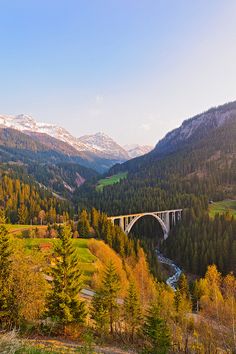 a bridge over a river surrounded by mountains