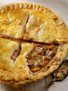 a close up of a pie on a table with a spoon and fork next to it