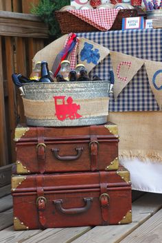 three suitcases stacked on top of each other in front of a table with flags