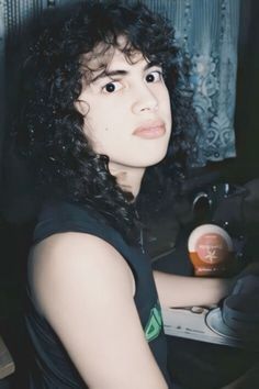 a woman with curly hair sitting at a desk