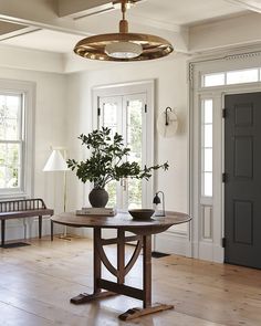 a table with two vases on top of it in front of some doors and windows