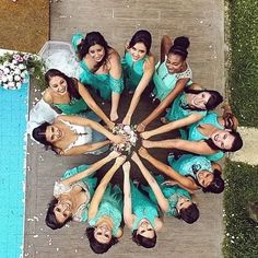 a group of women standing around each other in front of a swimming pool with their hands together