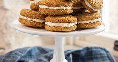 a stack of cookies sitting on top of a white cake plate