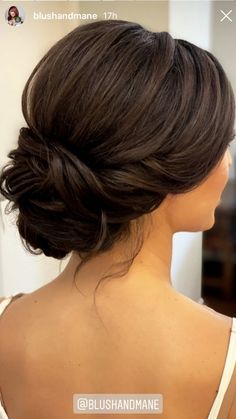 the back of a woman's head with her hair in a low bun