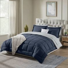 a bed with blue and white comforters in a bedroom