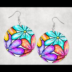 a pair of earrings with colorful flowers painted on the front and back of each ear