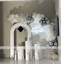 an arch with balloons and candles on the floor