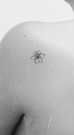 the back of a woman's shoulder with a small tattoo on her left side