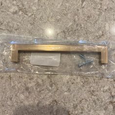 a door handle is wrapped in plastic and sitting on the floor next to some screws