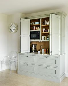 a kitchen with white cabinets and a clock on the wall