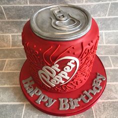 a red birthday cake with the words happy birthday written on it and an aluminum can