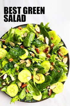 a salad with lettuce, cucumbers and almonds in a black bowl