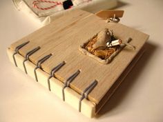 a wooden notebook with some metal pins sticking out of it