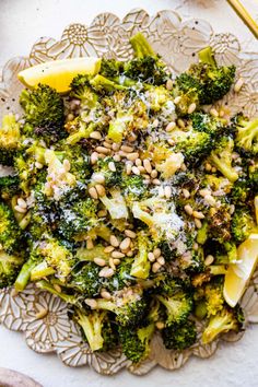 broccoli salad with lemon wedges and parmesan cheese on a plate