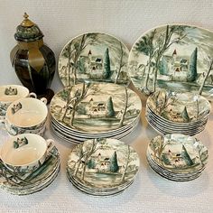 a table topped with lots of plates and cups