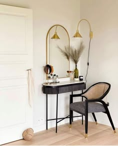 a chair sitting next to a table with a mirror on top of it and a lamp