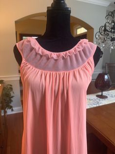 A beautiful vintage nightgown in peach.  This sleeveless gown has a sheer panel on the neckline with ruffle trim.  In good vintage condition with no rips or stains.  The bust measures 17.5 inches from armpit to armpit laying flat.  48.5 inches from shoulder to hem. Please examine the pics, feel free to ask questions. Sleeveless Ruffled Dress For Sleepover, Flowy Sleeveless Sleepwear For Loungewear, Sheer Sleeveless Nightgown For Party, Sheer Sleeveless Nightgown For Pajama Party, Sheer Sleeveless Sleepwear For Pajama Party, Sleeveless Ruffled Loungewear Dress, Sleeveless Ruffled Dress For Loungewear, Vintage Sleeveless Ruffled Sleepwear, Vintage Sleeveless Spring Sleepwear