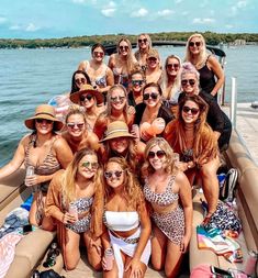 a group of women in bathing suits and hats on a boat posing for a photo