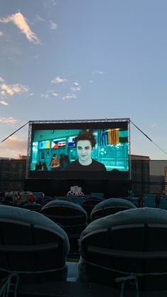 an outdoor movie screen with seats in front of it