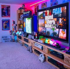 a living room with two televisions and video game controllers on the entertainment center table