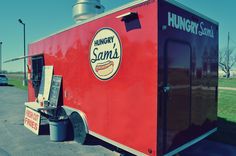 the hungry sam's food truck is parked on the side of the road with its door open