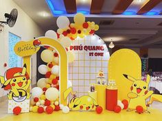 an entrance to a restaurant decorated with balloons and pikachu figures on the floor