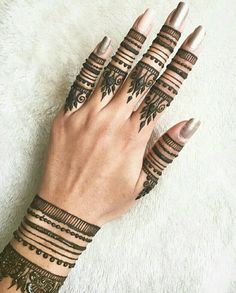 a woman's hands with hennap tattoos on their fingers and wristbands