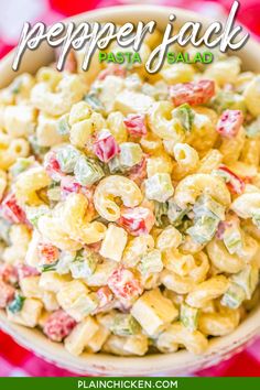 a bowl filled with macaroni salad on top of a red and white checkered table