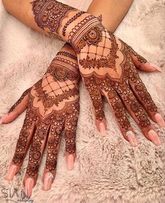 two hands with henna tattoos on them