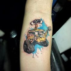 a person with a small tattoo on their arm that has a cartoon character driving a tractor