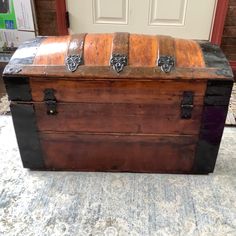 an old trunk is sitting on the floor in front of a door and carpeted area