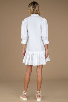 Say hi to our Chloe Dress, a new design we are sure you will obsess over. The Chloe Dress is a tunic-style swing silhouette featuring a slight high-low ruffle detailed skirt hem, giving her the ideal, flirty mini length. Ruffle detailing also trims the V-neckline, enhancing the style's femininity while seamlessly keeping her sophisticated with a three-quarter length, wide, button cuff sleeve. This mini dress can be styled up or down with ease. Chloe's versatility keeps her effortlessly chic from Cotton Mini Hem Dress For Brunch, Knee-length Mini Dress With Ruffle Hem For Casual Wear, Brunch Mini Dress With Ruffle Hem, Feminine A-line Midi Dress With Ruffle Hem, White Ruffle Hem Mini Dress, Knee-length Mini Dress With Ruffle Hem For Brunch, Ruffled Mini Hem Dress For Brunch, Flowy Knee-length Puff Sleeve Dress With Ruffle Hem, Fitted Mini Hem Daywear Dresses