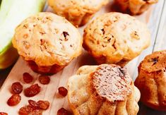 several muffins with raisins on a cutting board next to some bananas