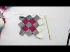 there is a crochet pattern on the table next to yarn and knitting needles