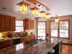 a large kitchen with wooden cabinets and marble counter tops, along with an island in the middle