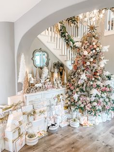 a decorated christmas tree sitting in the middle of a living room next to a fireplace