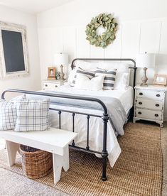 a bedroom with a bed, dressers and a basket on the floor in front of it