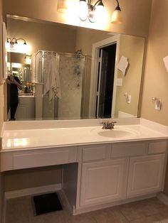 a bathroom with a sink, mirror and lights